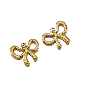 Close-up of golden bow-shaped metal jewelry pendants with top hanging loops
