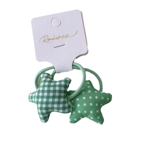 Set of two green star-shaped hair ties with checkered and polka dot fabric patterns