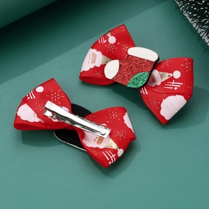 Detail showing red Christmas bow hair clips with Santa Claus print and sequin sock decoration