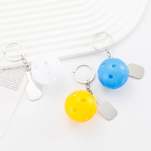 Three-piece pickleball keychain set with blue, yellow, and white balls and metal paddle charms