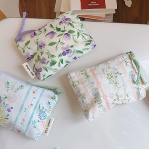 Detailed view of three cotton pouches with floral and striped prints and woven pulls