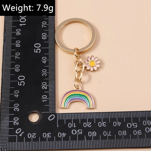 Rainbow and daisy floral keychain detail with scale showing its 7.9g weight