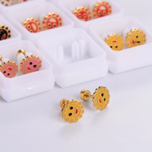 Macro shot of colorful sunflower earrings with yellow enamel finish on white background