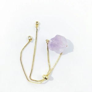 Detail of adjustable gold box chain with irregular raw purple amethyst crystal stone