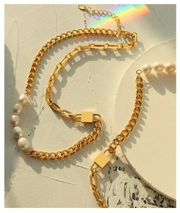 Close-up of golden Cuban chain with freshwater pearls and metallic lock details