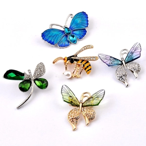 Set of crystal-encrusted butterfly and bee brooches with pearls on white background