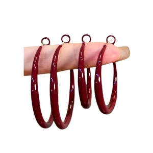 Burgundy red large hoop earrings in S925 silver finish displayed on fingers
