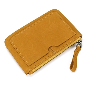 Close-up of yellow suede leather coin purse with front card slot and metal zipper details