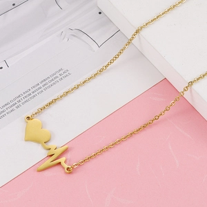Collana con ciondolo a cuore battente dorato lucido per donna su sfondo minimalista