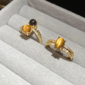 Vintage gold plated tiger eye ring set with sparkling zircon accents on gray velvet