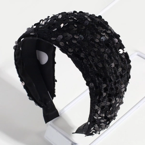 Close-up of black sequin headband with soft velvet base on a professional stand