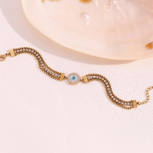 Detailed macro view of 18K gold plated evil eye bracelet with layered chains and zircons