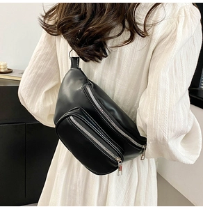 Detail view of black PU leather chest bag with chain and dual zipper compartments