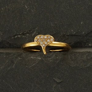 Macro shot of 18k gold ginkgo leaf ring with sparkling crystals set on a dark rock
