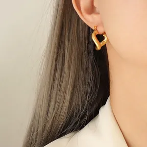 Elegant 18k gold plated stainless steel twisted heart hoop earrings worn by a model