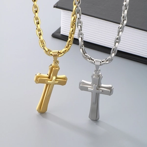 Close-up of dual-layer stainless steel cross pendants in gold and silver finishes