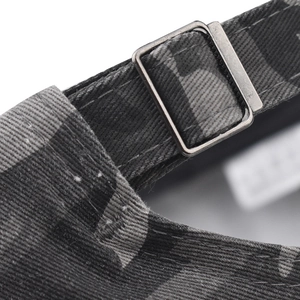Macro detail of the adjustable metal buckle and camouflage fabric on the baseball cap