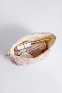 Detail showing the large interior capacity of this floral lace makeup bag with cosmetics