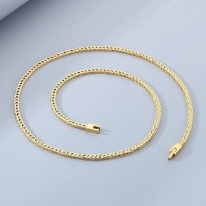 Macro shot of gold-plated stainless steel Chopin chain texture on blue background