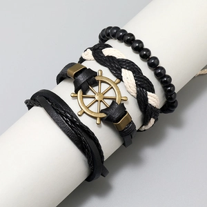 4-piece vintage black leather bracelet set with bronze rudder charm on display stand