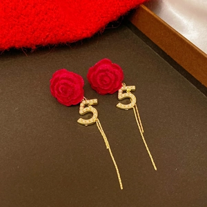 Detail of red velvet rose earrings with gold number 5 and pearl tassel fringe