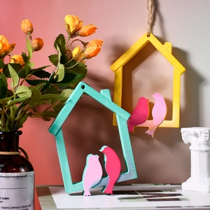 Detail view of bird-shaped wooden wall plaques in yellow and mint green home decor