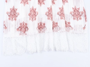 Dettaglio dell'orlo plissettato con stampa floreale boho rosa e bordo in pizzo bianco