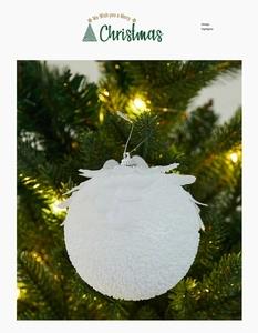 Close-up of white textured foam Christmas ball with petal leaf detail on tree