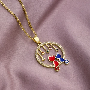 Gold cat pendant necklace with red blue enamel and zircons on purple velvet