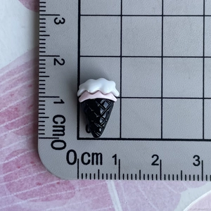 Macro view of a 1.5cm black and pink resin ice cream miniature for nail art and DIY crafts