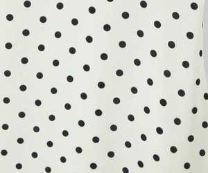 Primer plano del patrón de lunares negros en tela blanca para vestido vintage