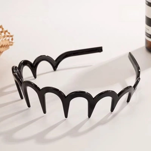 Détail d'un serre-tête ondulé noir brillant avec dents pour une fixation sûre