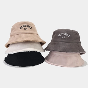 Multiple colors of suede bucket hats with lamb wool trim and Baby Girl embroidery