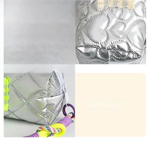 Close-up of heart-quilted silver metallic pouch with colorful braided handle detail