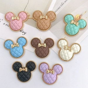Flat lay of Mickey-shaped charms with diamond patterns and golden bow accents in 8 colors