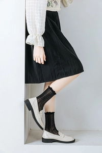 Detail view of black mesh lace crew socks paired with beige loafers for a lolita look