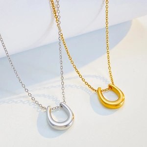 Polished gold and silver horseshoe U-shaped titanium steel necklaces set on white background