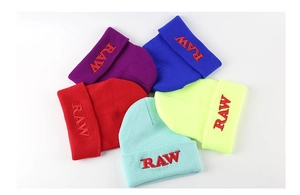 Detail of five colorful beanies featuring RAW embroidery on the folded cuff