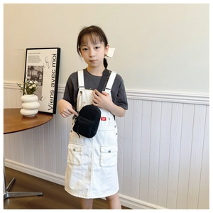 Detailed view of child model wearing a black mini nylon crossbody bag for casual style