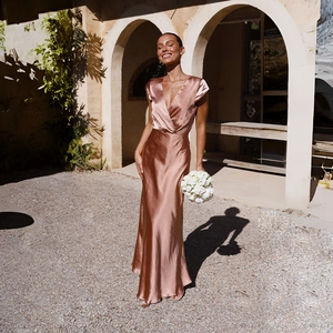 Detail of elegant satin fishtail dress showing glossy fabric and deep V-neckline