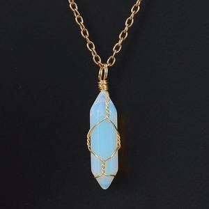Macro detail of wire-wrapped opal hexagonal prism pendant with elegant gold chain
