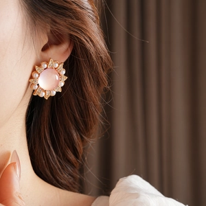Gros plan de boucles d'oreilles vintage avec pierre rose, perles et cristaux