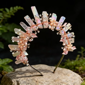 Detail of handmade crown featuring pink crystal shards and rhinestones on mossy stone