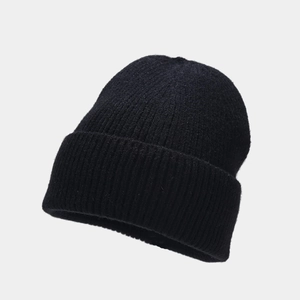 Detail of black knit beanie featuring thick texture and classic folded cuff design