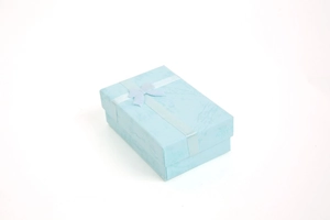Close-up of light blue jewelry gift box with water ripple texture and silk ribbon bow