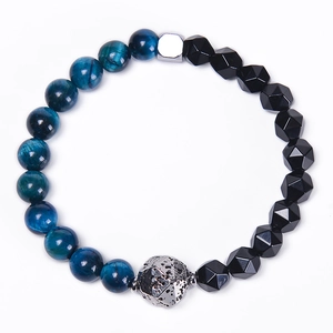 Detail of blue tiger eye and obsidian beaded bracelet with textured silver metal focal bead