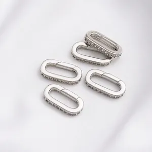 Ovale Federverschlüsse in Silber mit Zirkon-Inlay für DIY-Schmuck auf weißer Seide