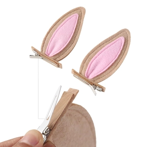 Close-up of pink and tan felt rabbit ear hair clips with silver metal alligator grip