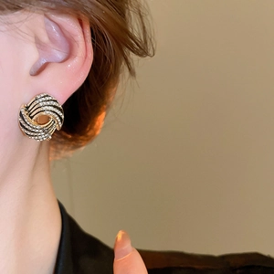 Elegant twisted geometric earrings with black enamel and diamonds on a gold base