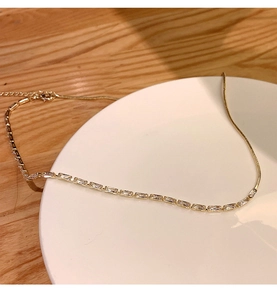 Detail of gold snake chain necklace featuring a row of rectangular cubic zirconia stones